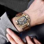 Man wearing a gold Swiss watch on the wrist
